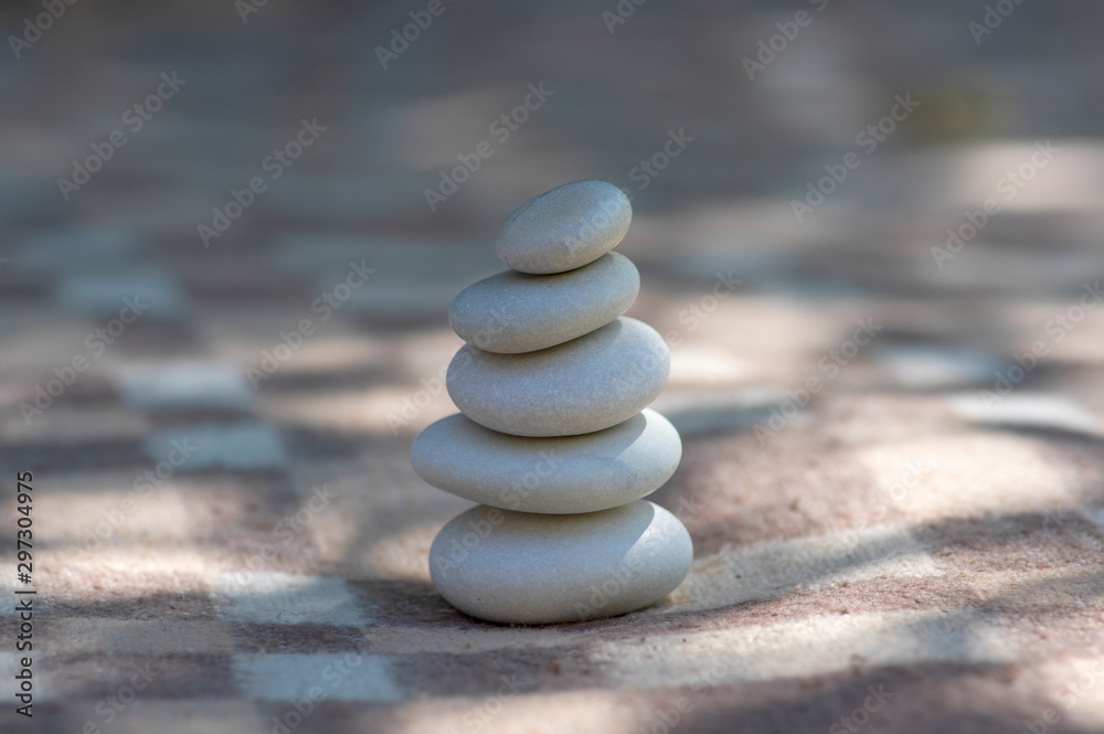 Fototapeta premium Harmony and balance cairns, simple poise stones on white and brown textile checkered background