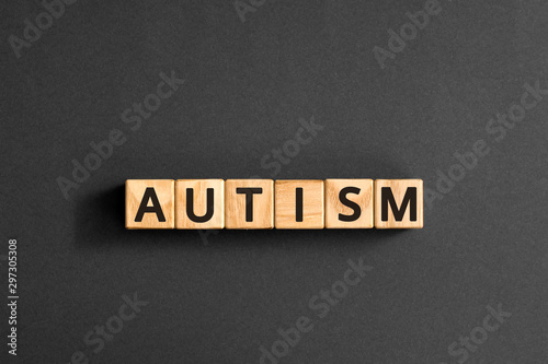 Autism - word from wooden blocks with letters, autism spectrum disorder (ASD) concept,  top view on grey background
