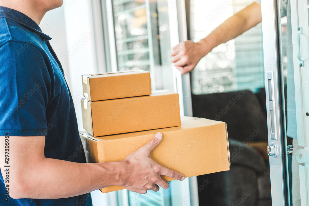 Delivery Asian man service with boxes in hands standing in front of Customer's house doors Delivery Asian man service with boxes in hands standing in front of Customer's house doors