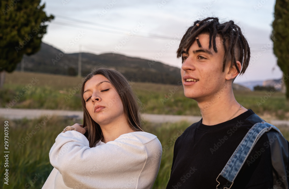 Happy young couple dressed casual in a sunset. Girl and guy kissing Happy young couple dressed casual in a sunset. Girl and guy kissing