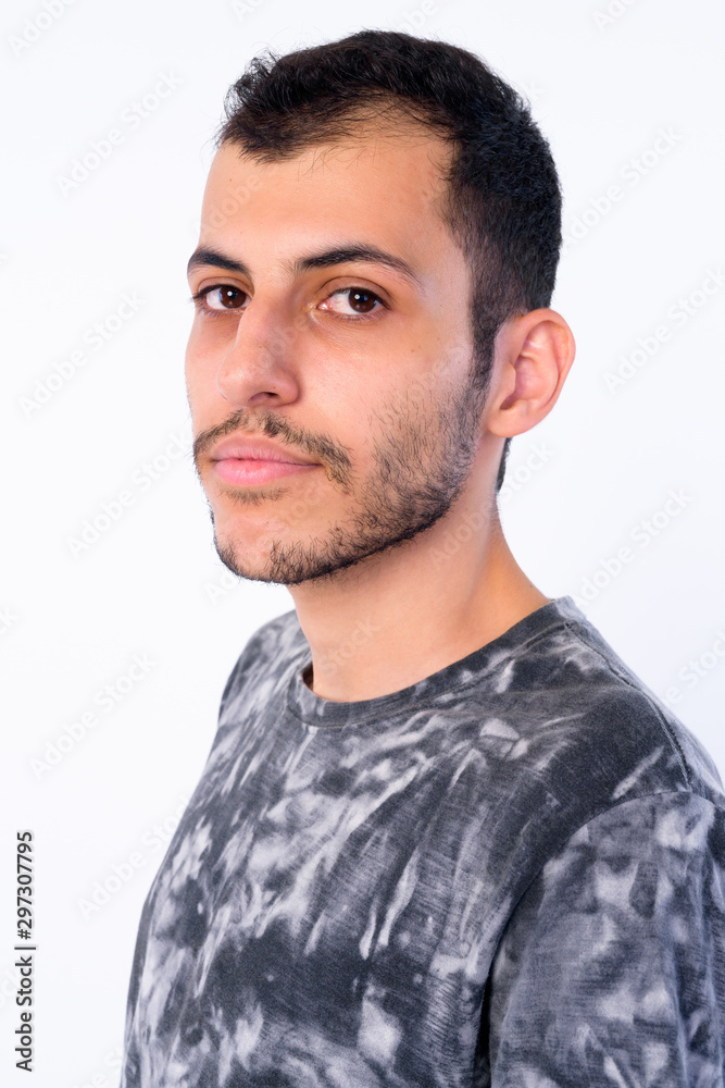 Fototapeta premium Closeup profile view of young bearded Persian man looking at camera