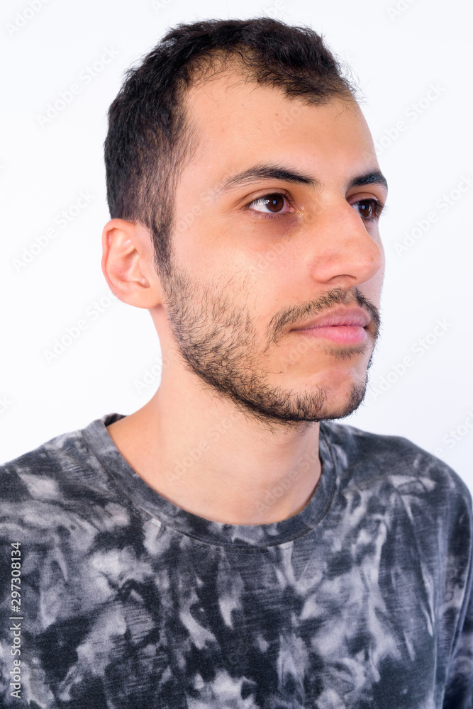 Fototapeta premium Face of young bearded Persian man thinking and looking away