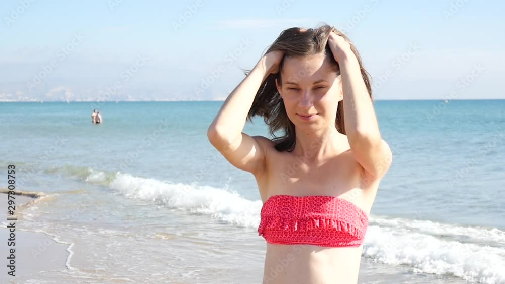 Young beautiful Woman Brunette shakes her Head and Hair on a Sea Beach Young beautiful Woman Brunette shakes her Head and Hair on a Sea Beach