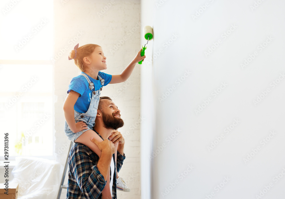 Repair in apartment. Happy family father and child daughter paints wall - obrazy, fototapety, plakaty 