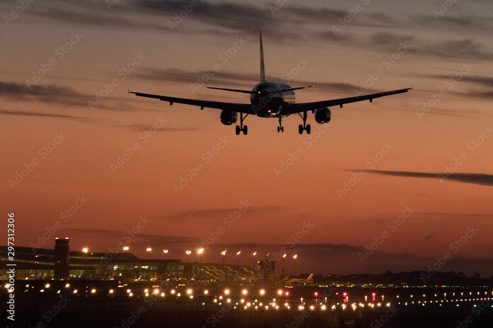 Airplane silhouette landing at the airport during sunser, Barcelona