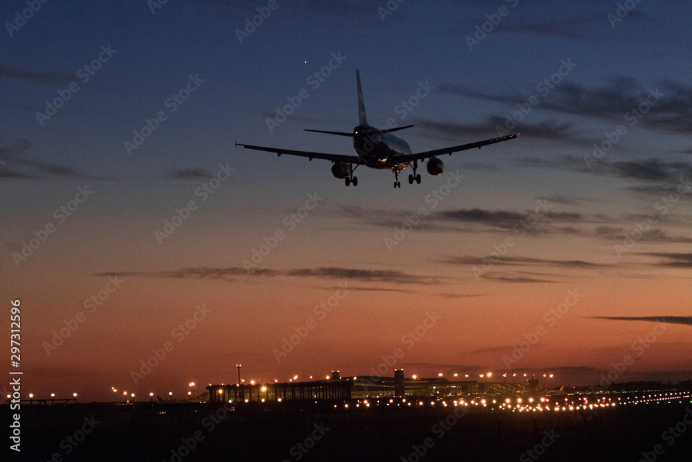 Airplane silhouette landing at the airport during sunser, Barcelona