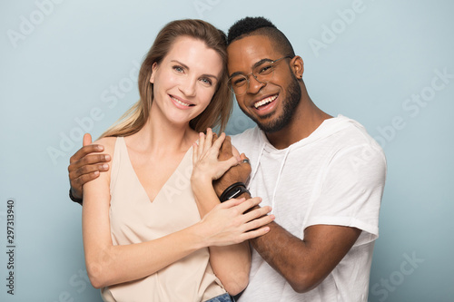 Portrait of happy multiethnic couple hugging posing together