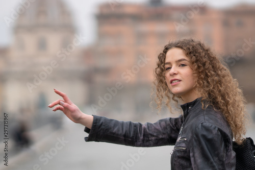 Woman waving for a taxi ride in the streets of Rome, Italy