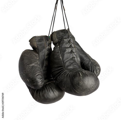 pair of very old vintage black leather boxing gloves hanging on a rope © nndanko