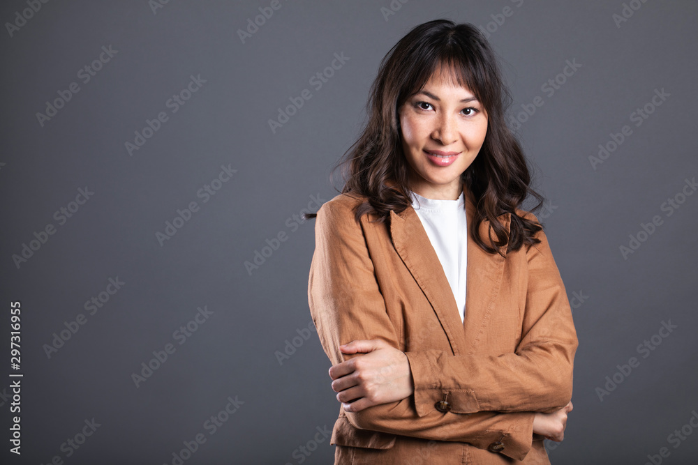Portrait of successful business asian women with arms crossed and smile isolated over gray background. Portrait of successful business asian women with arms crossed and smile isolated over gray background.