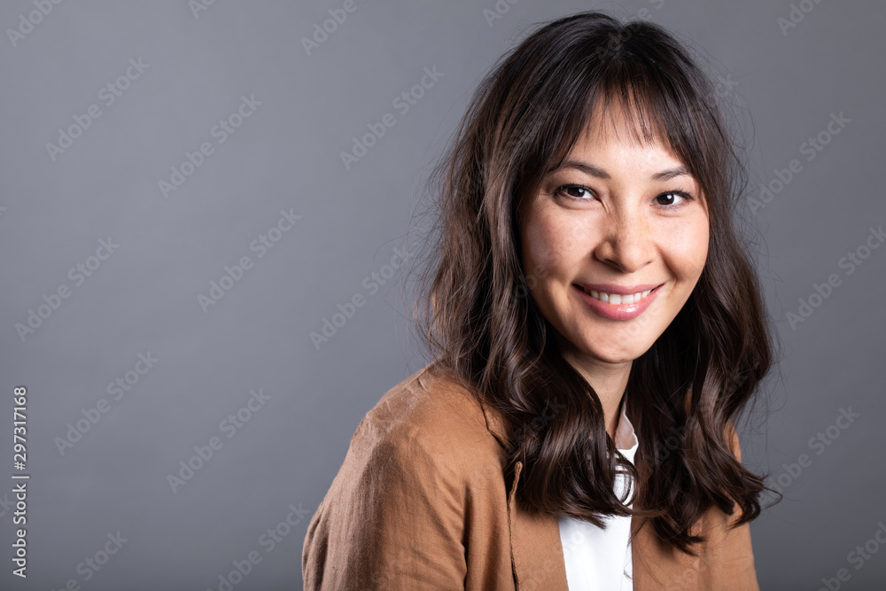 Beautiful asian smiling woman on gray background. Beautiful asian smiling woman on gray background.