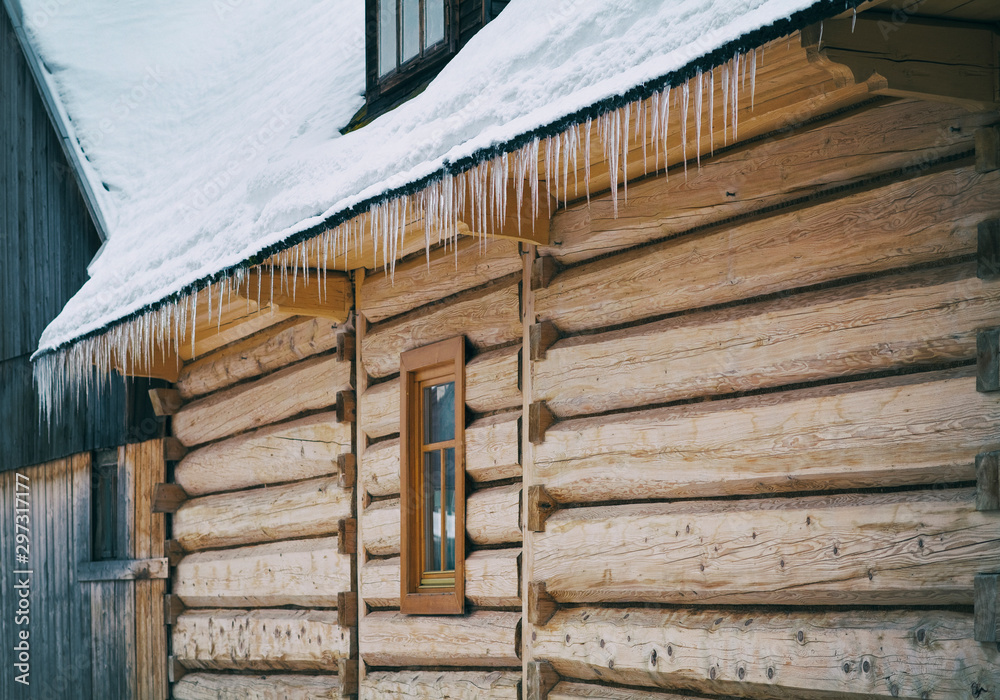 Icicles hanging from the roof of the old, rustic house. Icicles hanging from the roof of the old, rustic house.
