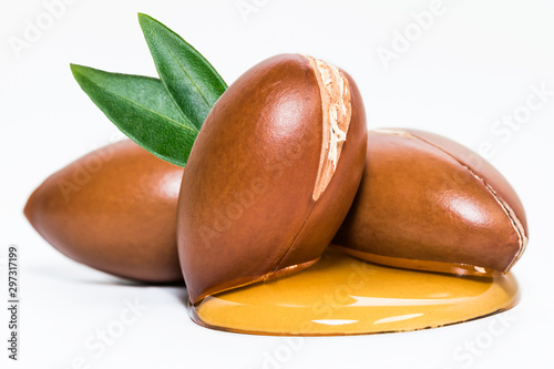 Argan nuts and oil on white background