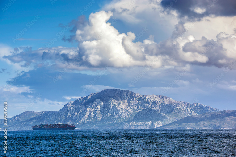 Barco mercante surcando el Estrecho de Gibraltar con la montaña Jebel Musa (Africa) al fondo.