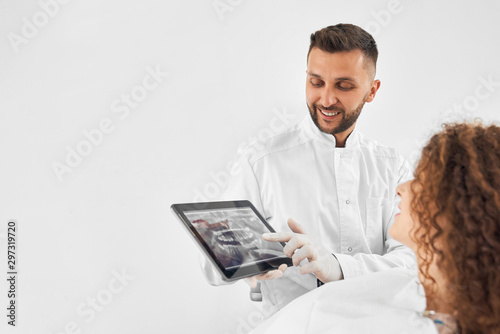 Nice male dentist keeping tablet with x ray picture of teeth