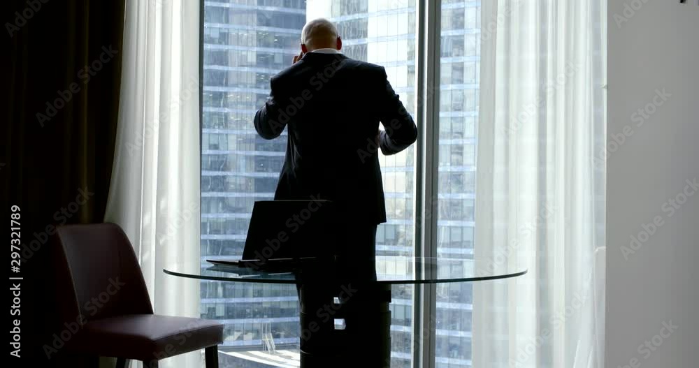 businessman talks on cellphone near window slow motion businessman talks on cellphone near window slow motion