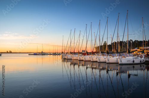 Fototapeta Naklejka Na Ścianę i Meble -  Boats docking in the marina at the Niegocin Lake during sunrise. Wilkasy, Masuria , Poland.