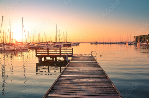 Pier on the Niegocin Lake and boats docking in the marina during sunrise. Wilkasy, Masuria , Poland.