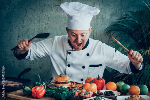 Funny chef looking at food on the wood table exciteing mood