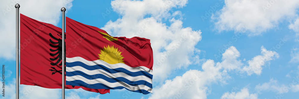 Albania and Kiribati flag waving in the wind against white cloudy blue sky together. Diplomacy concept, international relations. Albania and Kiribati flag waving in the wind against white cloudy blue sky together. Diplomacy concept, international relations.