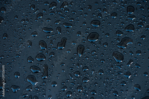 Closeup of rain drops of black metaliic surface photo
