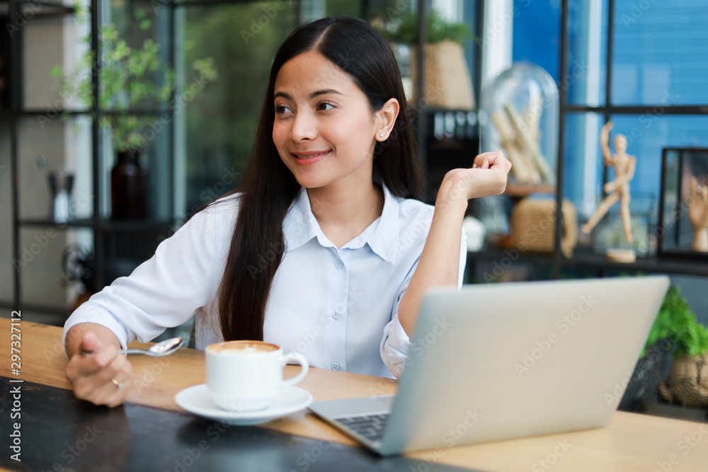 Asian woman working and drink coffee in cafe with laptop computer smile and happy work Asian woman working and drink coffee in cafe with laptop computer smile and happy work