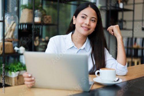 Asian woman working and drink coffee in cafe with laptop computer smile and happy work