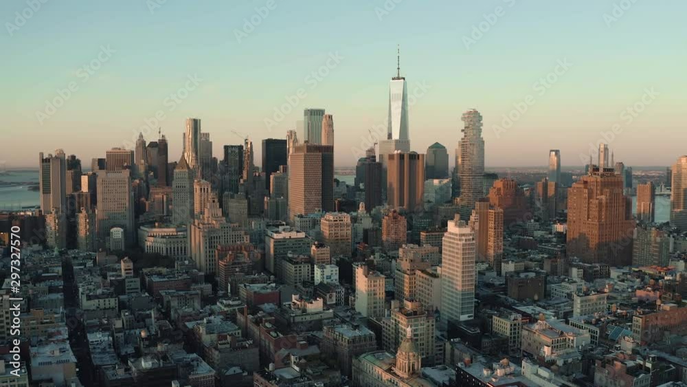 Flying towards Lower Manhattan Downtown business district at sunrise, skyline of New York with morning light Flying towards Lower Manhattan Downtown business district at sunrise, skyline of New York with morning light