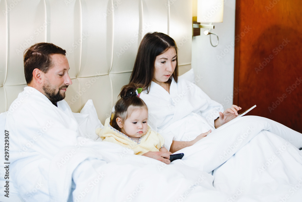 Obraz premium Mom, dad and daughter in bed.