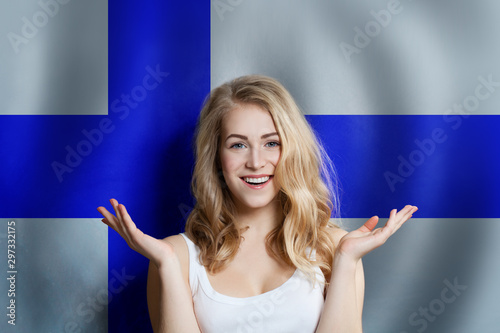 Beautiful happy young woman against the finnish flag background. Live, education and work in Finland