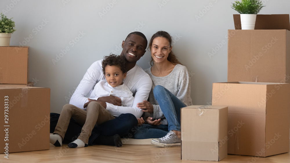 Portrait of happy multiracial family relocating to new home Portrait of happy multiracial family relocating to new home
