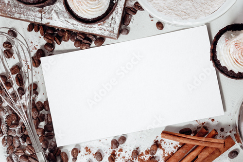 a piece of paper lies on the kitchen table among the cupcackes, sprinkled coffee, flour, sugar and cinnamon photo