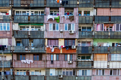 Facade of old apartment house. Slum house. Linen is dried on the balconies. Problem of overpopulation and poverty