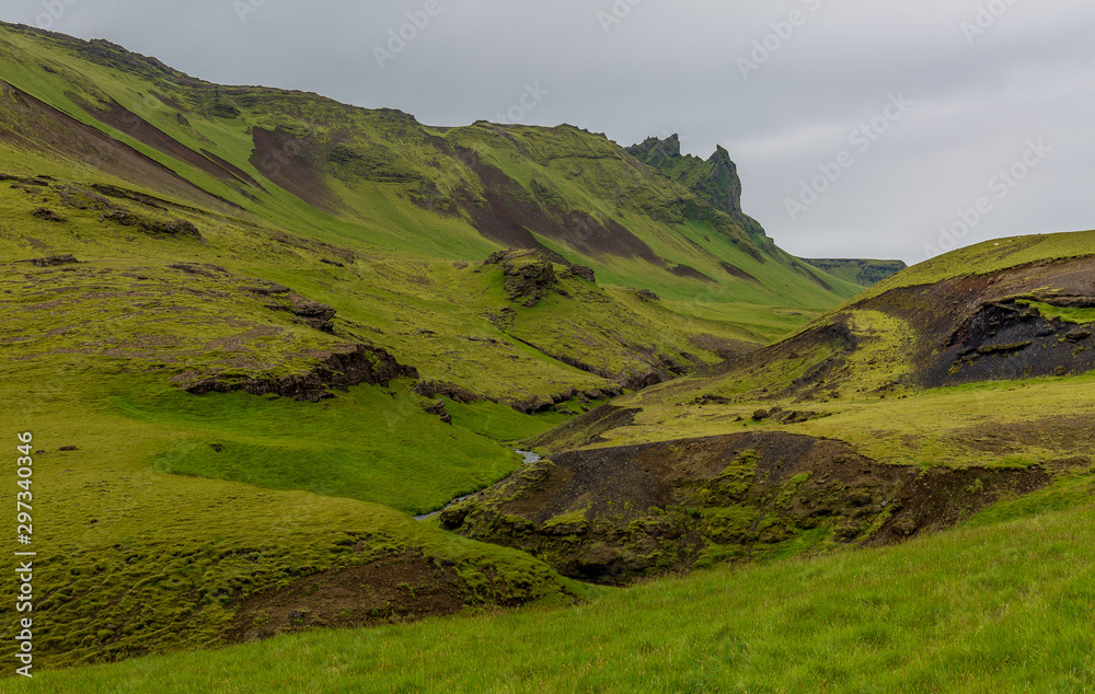 View of a mountain valley. Mountains covered in bright green grass