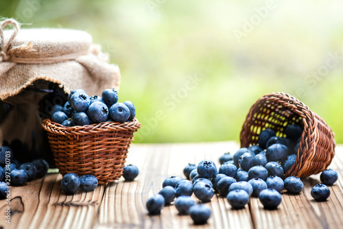 Photographie Blueberries in wicker basket and blueberry jam or marmalade