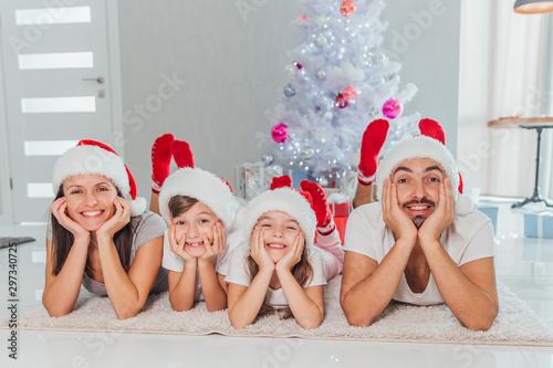 Cheerful large family having fun at home near Christmas tree, winter holidays, New Year celebration, parents with kids enjoying Christmastime