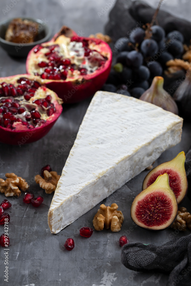 figs with cheese and pomegranate on ceramic background