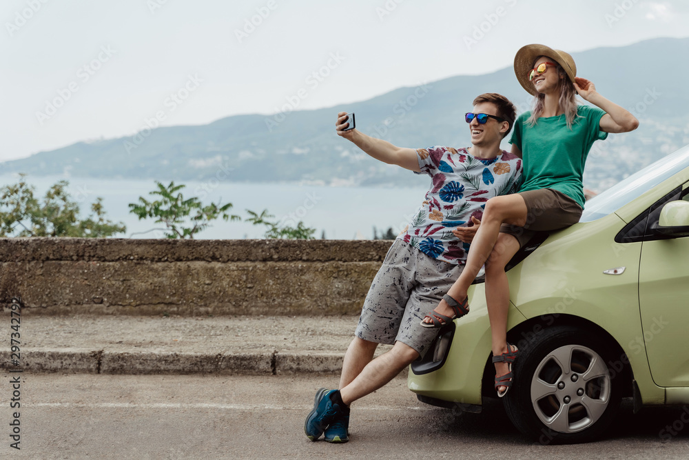 Obraz premium Travelers couple taking selfie with smart phone. Young man and woman taking self portrait while vacation