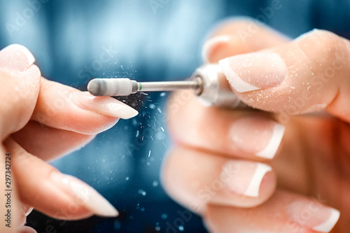 Carta da parati Woman use electric nail file drill in beauty salon