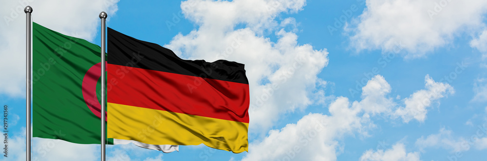 Algeria and Germany flag waving in the wind against white cloudy blue sky together. Diplomacy concept, international relations. Algeria and Germany flag waving in the wind against white cloudy blue sky together. Diplomacy concept, international relations.