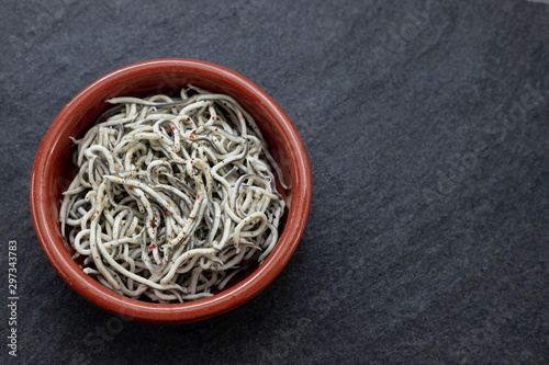 Traditional Spanish food. Gulas with oil in ceramic dish.