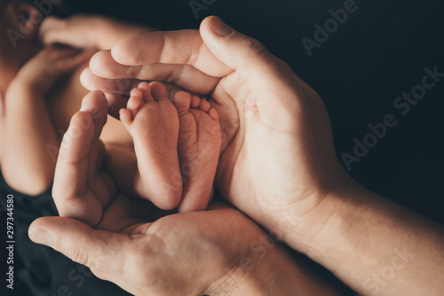 Newborn Baby's feet. Mother and father holding newborn baby legs,legs massage concept of childhood, health care, IVF, hygiene