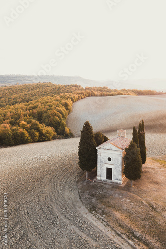 Aerial drone view of Cappella della Madonna di Vitaleta, Tuscany, Italy. Traditional italian architecture. Autumn landscape of Tuscan hills San Quirico D'Orcia. Empty agricultural fields in autumn. photo
