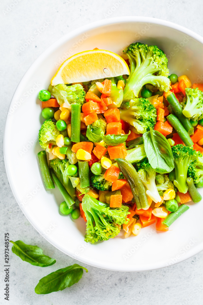 Steamed vegetables (broccoli, carrots, beans, peas, corn) in white plate, top view. Healthy diet food concept. Steamed vegetables (broccoli, carrots, beans, peas, corn) in white plate, top view. Healthy diet food concept.
