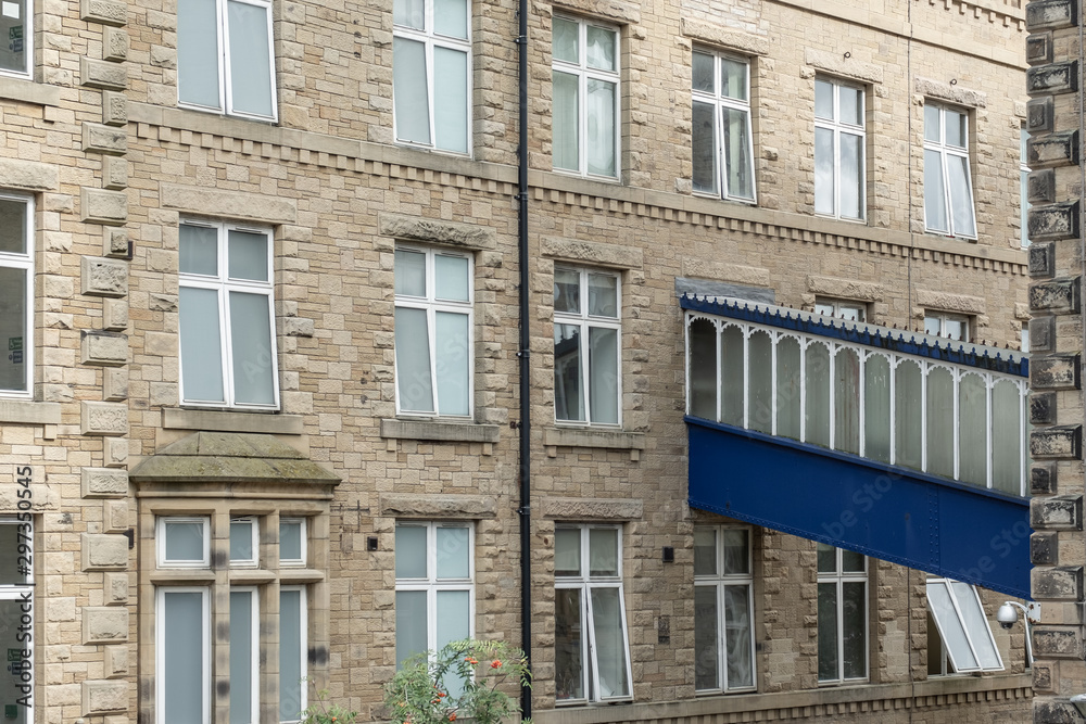  Architectural view of residential apartments seen at a formal mill and factory. Seen with an architectural, blue coloured walkway.