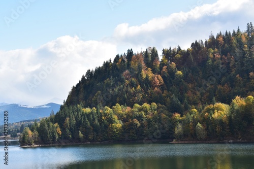 View of Colibita lake and fir forest, on a sunny day, in Carpathian mountains in Romania,Transylvania, Bistrita Nasaud county. photo