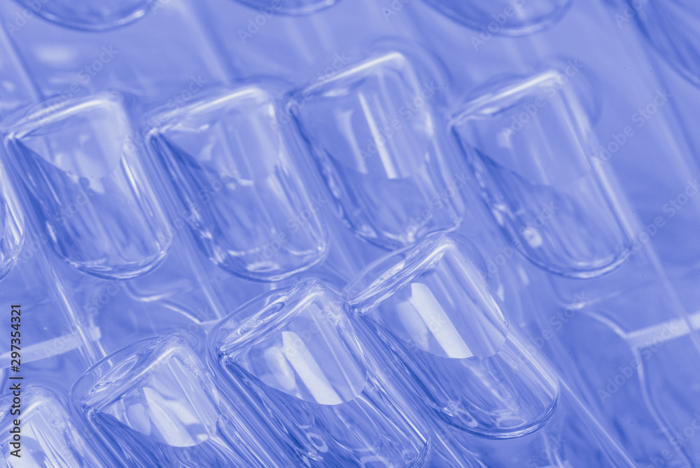 Glass medical ampoule vial for injection. Medicine is liquid sodium chloride with of aqueous solution in ampulla. Close up. Bottles ampule multicolor. Glass medical ampoule vial for injection. Medicine is liquid sodium chloride with of aqueous solution in ampulla. Close up. Bottles ampule multicolor.