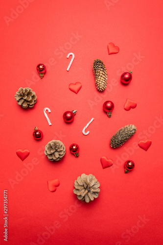 Border made of red background with pine cones, Christmas decoration silver stars, candy canes on red background.