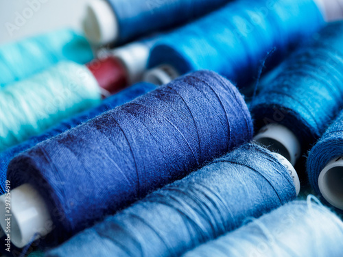 Lots of bobbins of thread for sewing. Threads of blue shade.