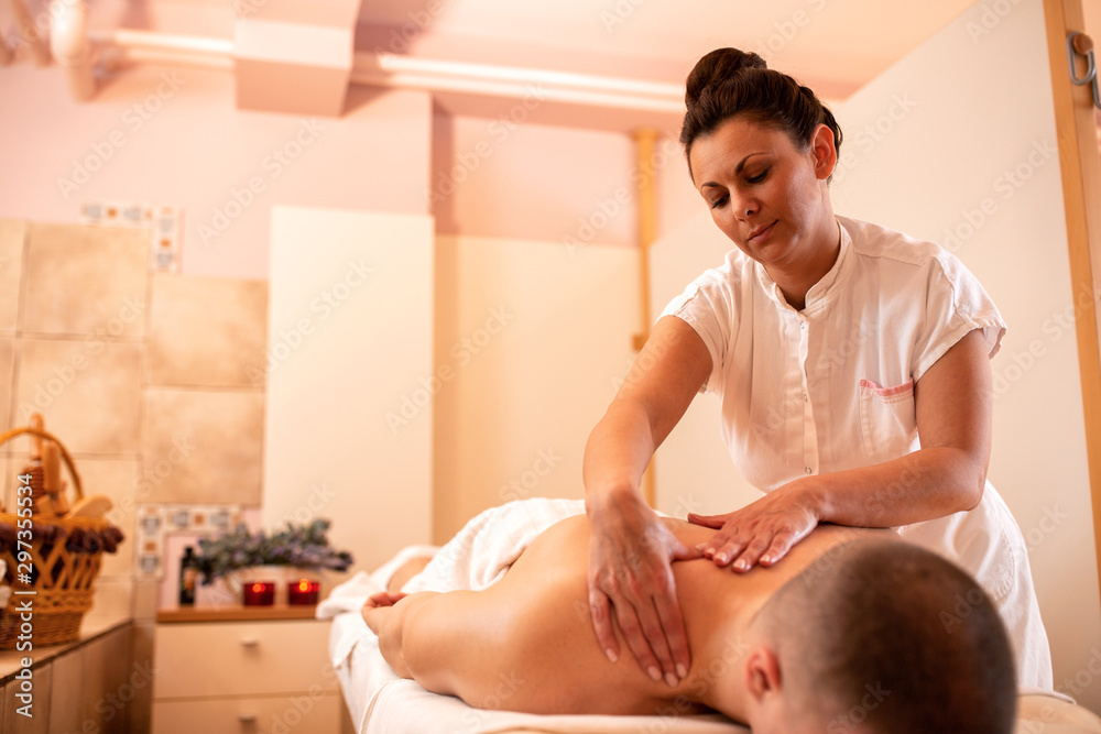 Obraz premium Masseuse applying movable pressure during a massage